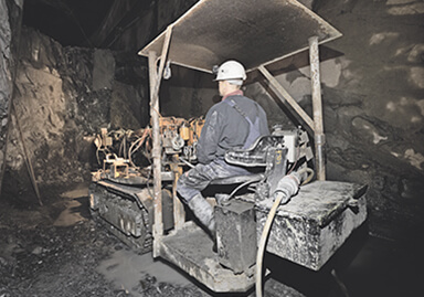 Ein Arbeiter sitzt in einem Bagger im Bergbauschacht