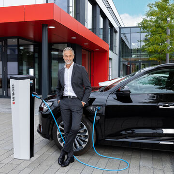 Unternehmer lädt sein Elektroauto an einer Ladesäule